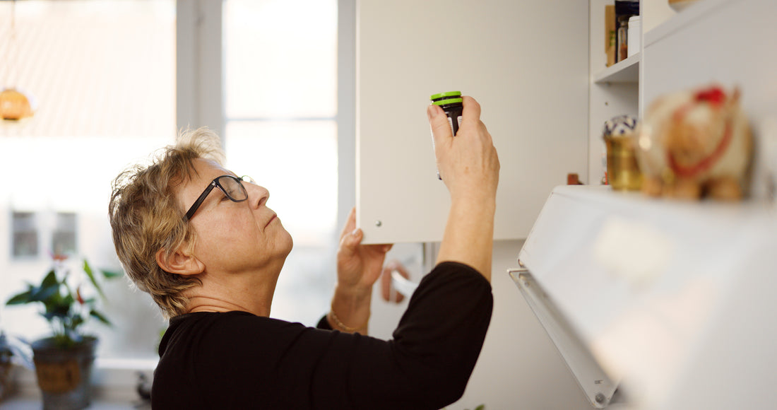 Senior woman looking for her medication in the cabinet