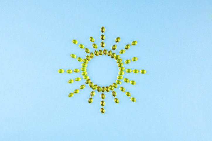  Yellow capsules with Vitamin D3 in the form of the sun with rays. 