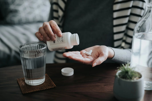 Woman pouring vitamin D capsules into her hand